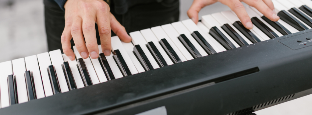 Close-up van iemand die keyboard speelt.