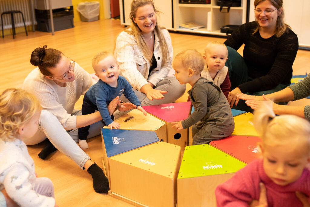 Kinderen spelen met muziekinstrumenten tijdens de les Muziek op Schoot