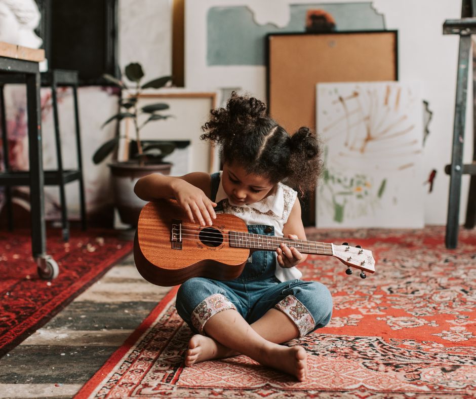 Meisje speelt gitaar als voorbeeld van Spelen met Muziek