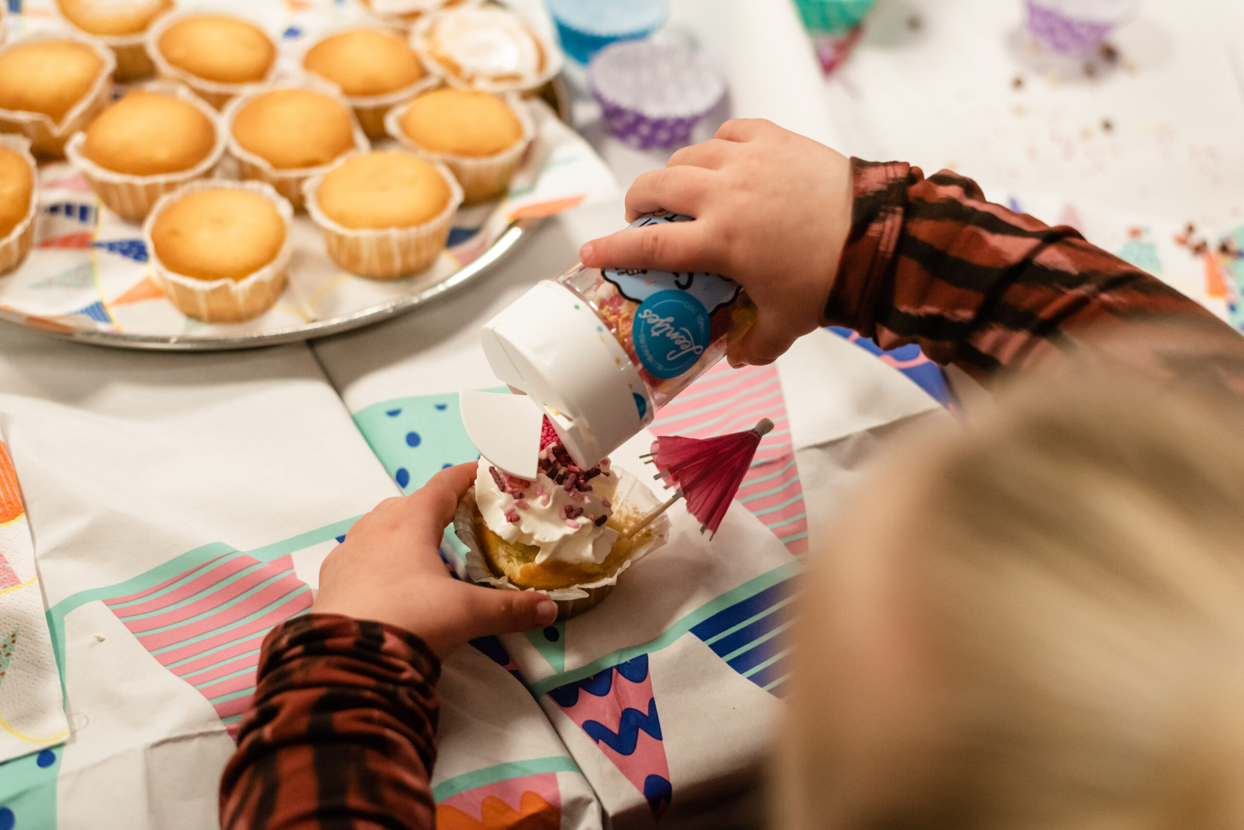 Meisje versiert cupcake tijdens kinderfeestje in Katwijk bij Planck.